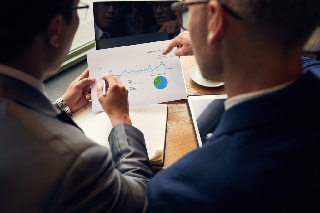 Business people analyzing aml risk activity statistics, view over the shoulder