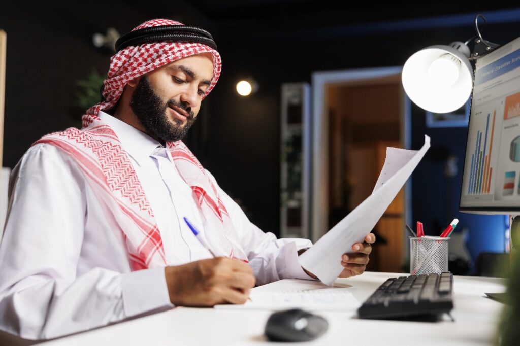 Businessman analyzing financial documents at desk.