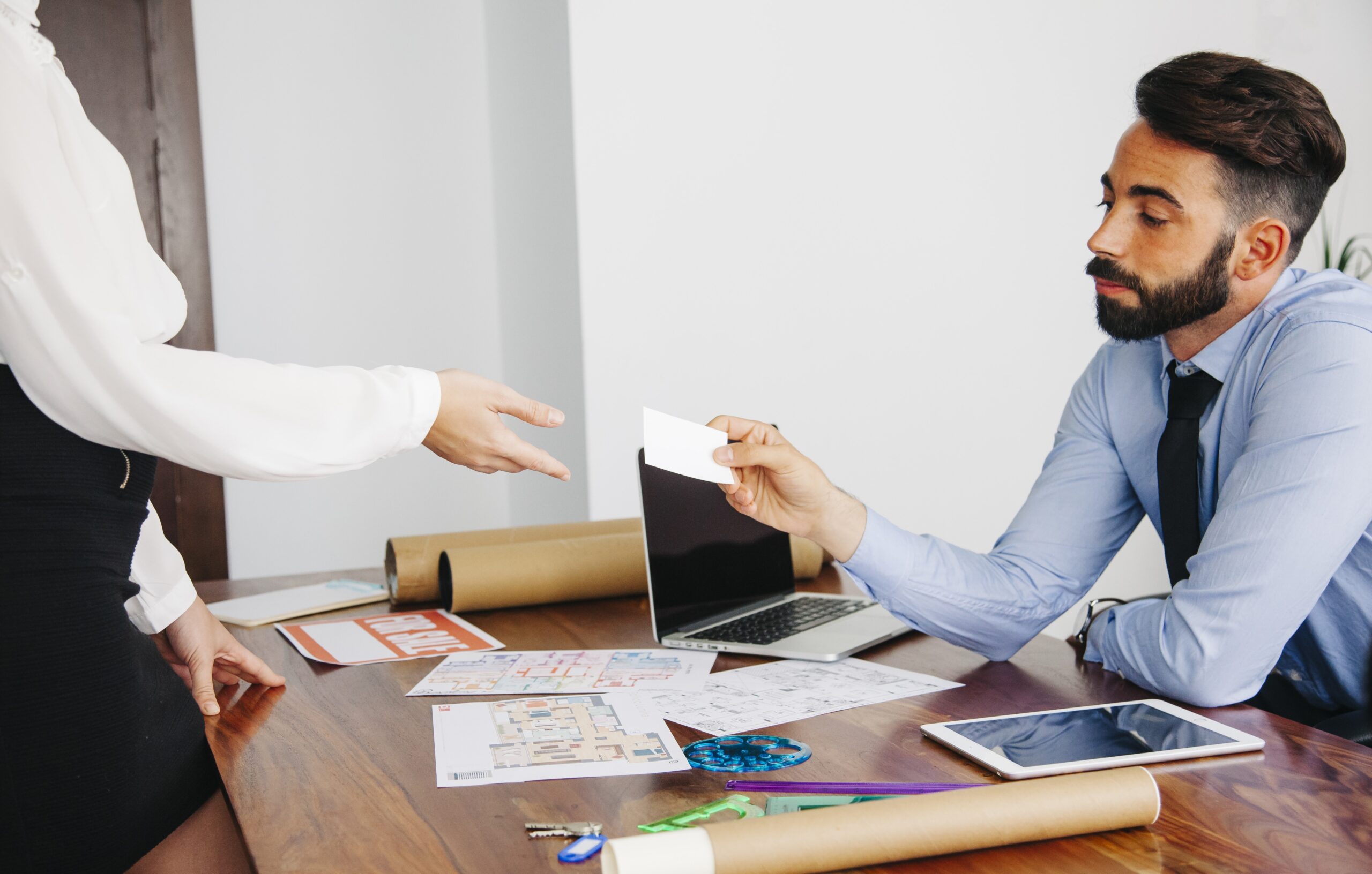 Business transaction with plans and laptop on table