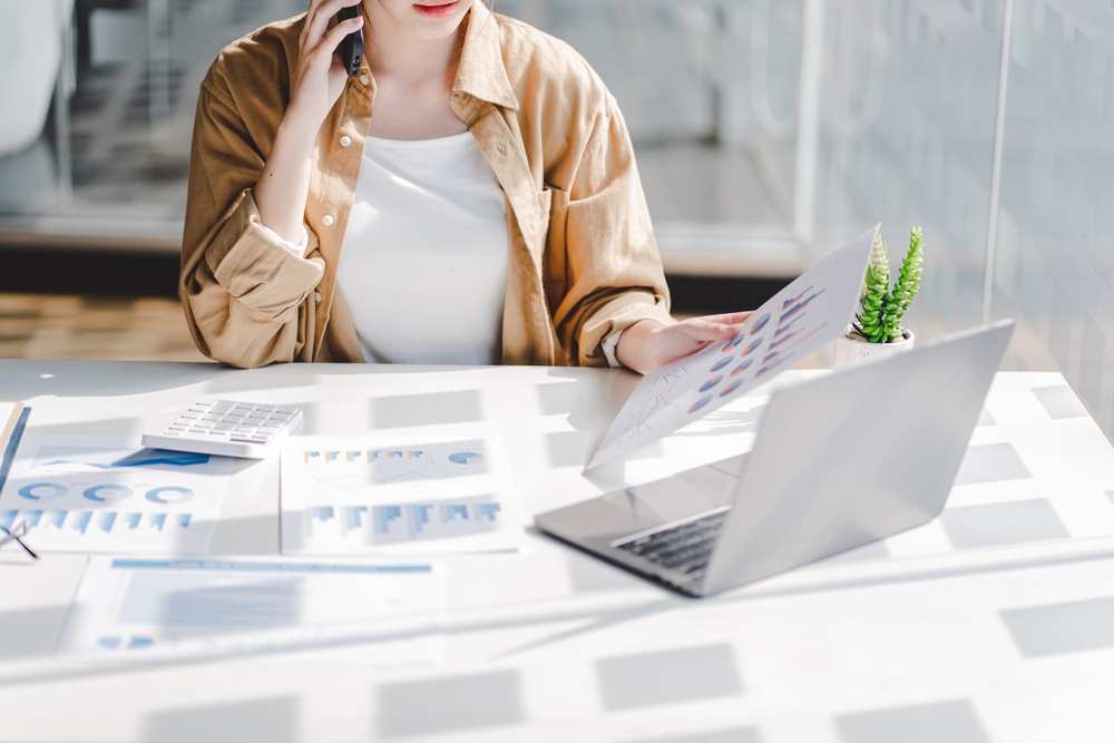 Woman analyzing financial charts by laptop